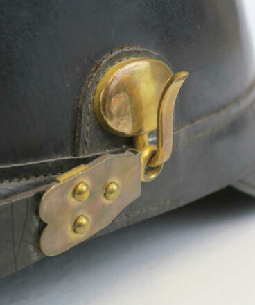 Haken für die seitliche Befestigung des Sturmriemens an einem Tschako des Modells 1887.